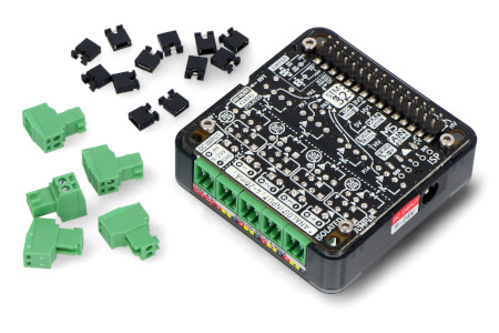 The black M5Stack analog to digital converter lies on a white background along with the components of the kit.